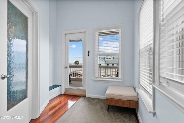 doorway with wood finished floors and baseboards
