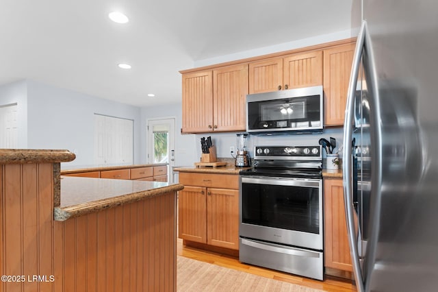 kitchen with stainless steel appliances, light wood-style flooring, light stone counters, and recessed lighting
