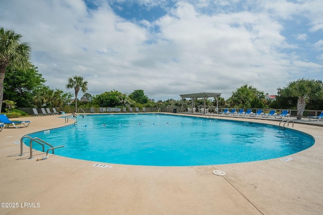 community pool with a pergola, fence, and a patio