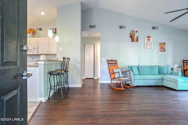 living room with vaulted ceiling, ceiling fan, and dark hardwood / wood-style flooring