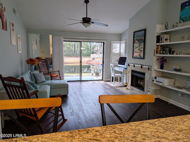 living room featuring ceiling fan, lofted ceiling, a fireplace, and hardwood / wood-style floors