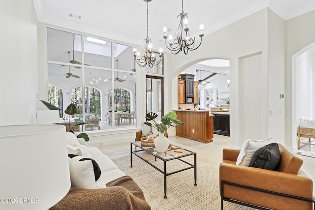 living area with crown molding, a high ceiling, ceiling fan with notable chandelier, and arched walkways