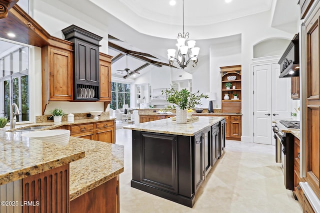 kitchen featuring decorative light fixtures, light stone counters, ceiling fan with notable chandelier, and a sink