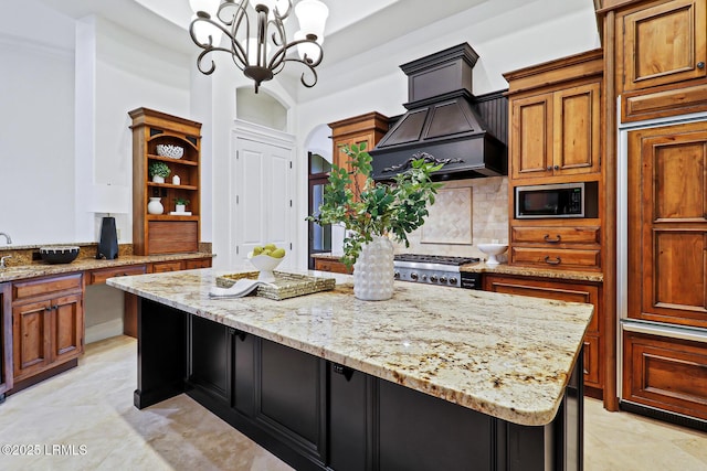 kitchen with light stone counters, appliances with stainless steel finishes, a kitchen island, and open shelves