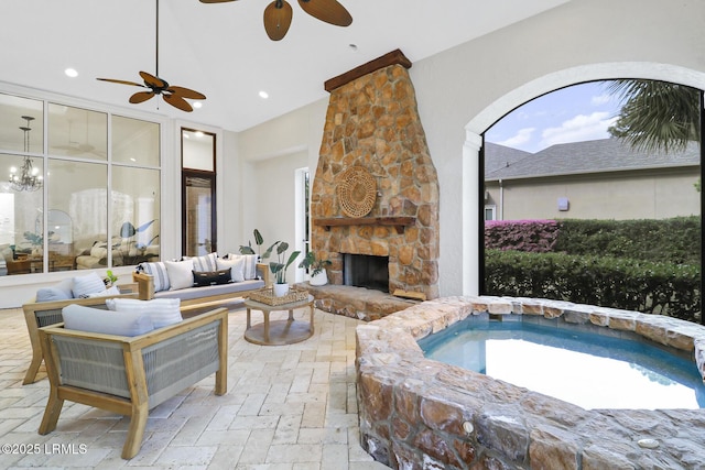 interior space with an outdoor living space with a fireplace, an in ground hot tub, and ceiling fan