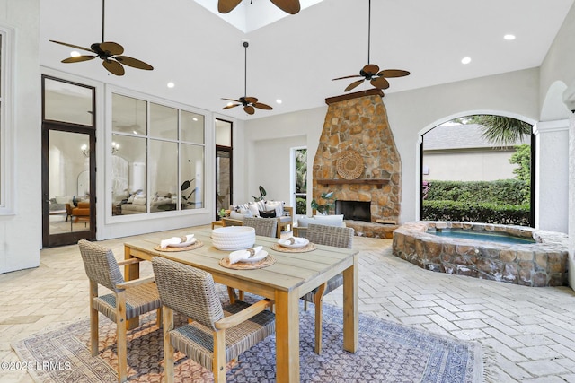 interior space with a stone fireplace, recessed lighting, brick floor, and ceiling fan