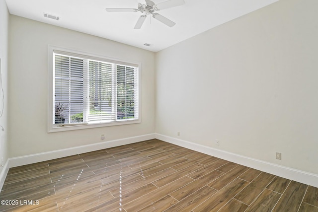 empty room with visible vents, baseboards, a ceiling fan, and wood tiled floor