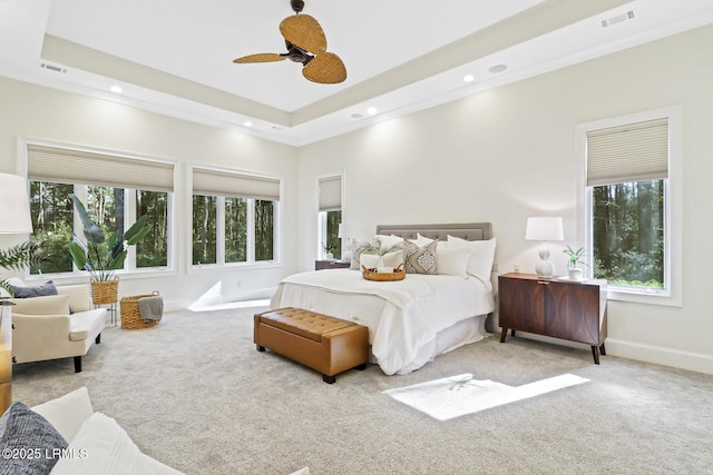 bedroom with a raised ceiling, carpet flooring, and visible vents