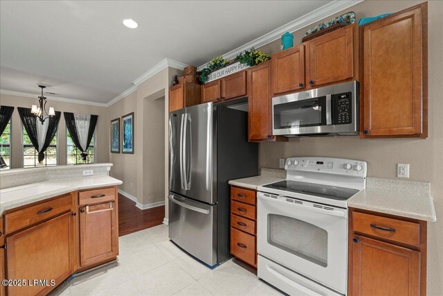 52 Summerplace Dr, Bluffton, SC 29909 - kitchen featuring appliances with stainless steel finishes, ornamental molding, light countertops, brown cabinetry, and a chandelier