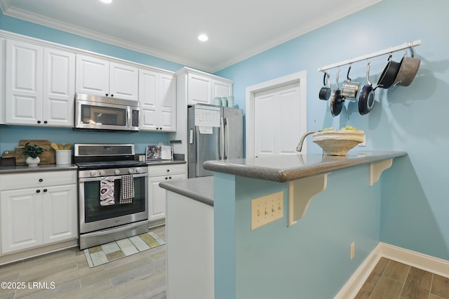 89 Bostick Cir, Beaufort, SC 29902 - kitchen featuring stainless steel appliances, wood finish floors, white cabinetry, ornamental molding, and a kitchen bar