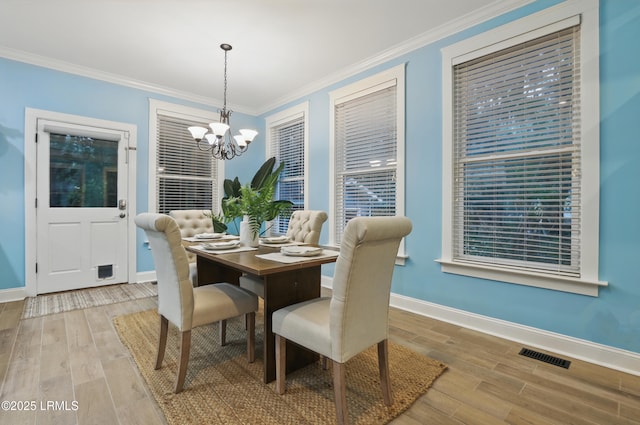 89 Bostick Cir, Beaufort, SC 29902 - dining area featuring baseboards, a chandelier, wood finished floors, and crown molding
