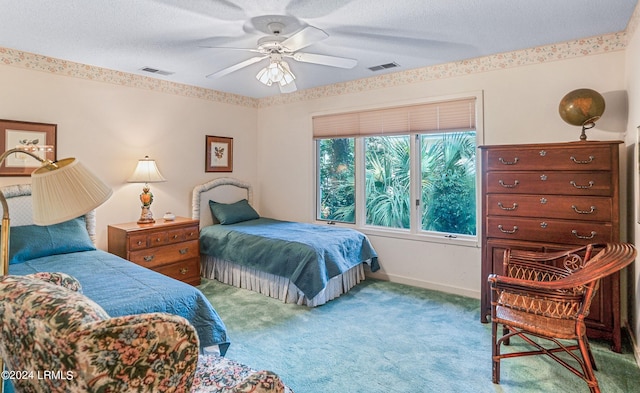 carpeted bedroom featuring a textured ceiling and ceiling fan