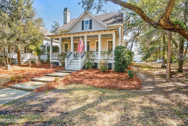 view of front of property featuring covered porch, roof with shingles, and a chimney