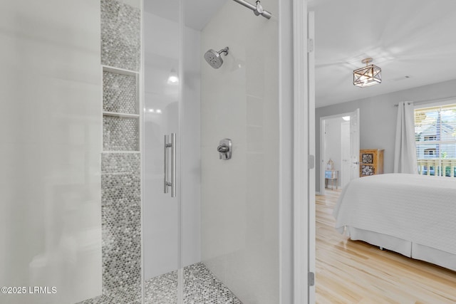 bathroom with wood-type flooring and tiled shower