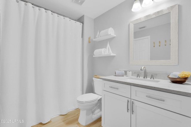 bathroom featuring vanity, toilet, and hardwood / wood-style floors