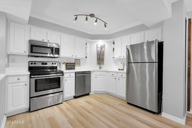 kitchen with sink, crown molding, light hardwood / wood-style flooring, appliances with stainless steel finishes, and white cabinets