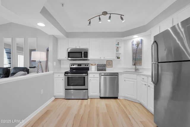 kitchen with sink, light wood-type flooring, white cabinets, and appliances with stainless steel finishes