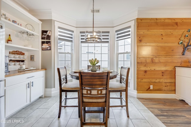 dining area featuring an inviting chandelier, light tile patterned floors, crown molding, and plenty of natural light