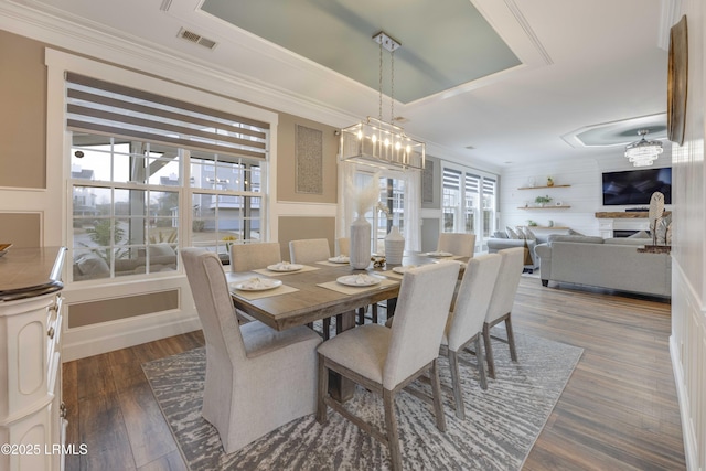 dining area featuring ornamental molding, a chandelier, and dark hardwood / wood-style flooring