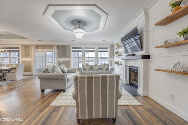 living room featuring crown molding, dark hardwood / wood-style floors, and a notable chandelier