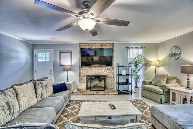 tiled living room with ornamental molding, a fireplace, and a ceiling fan