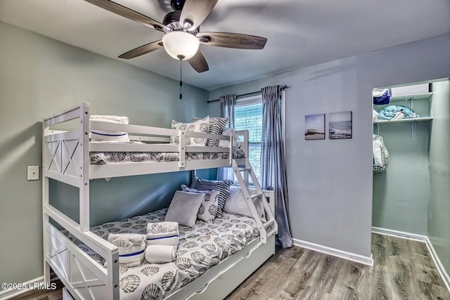 bedroom featuring wood finished floors, a ceiling fan, and baseboards