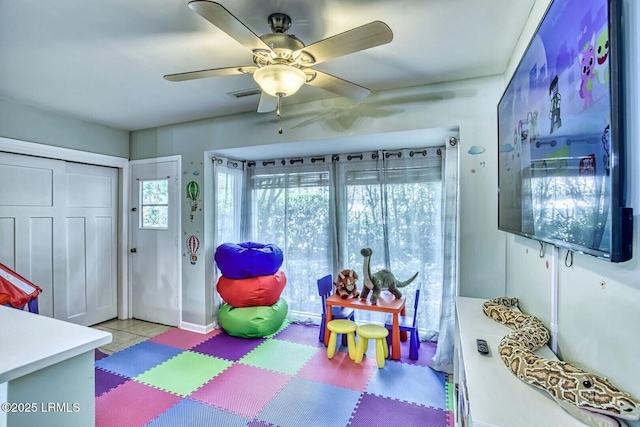 recreation room with tile patterned flooring, visible vents, and a ceiling fan