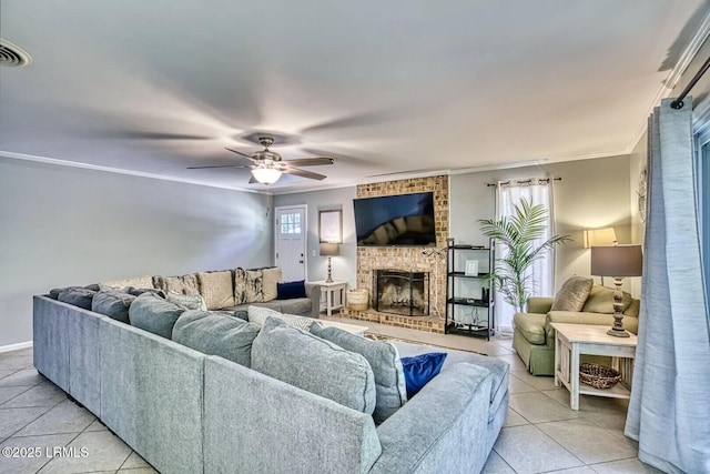 living area with ornamental molding, a wealth of natural light, a brick fireplace, and light tile patterned floors