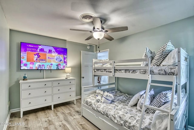 bedroom featuring wood finished floors, a ceiling fan, and baseboards