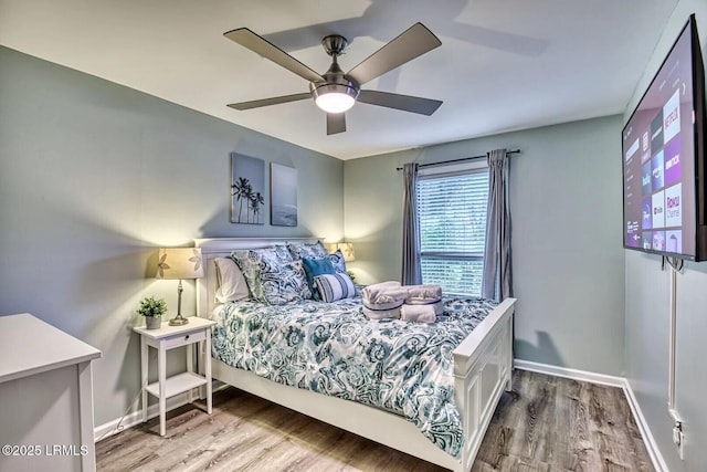 bedroom featuring a ceiling fan, baseboards, and wood finished floors