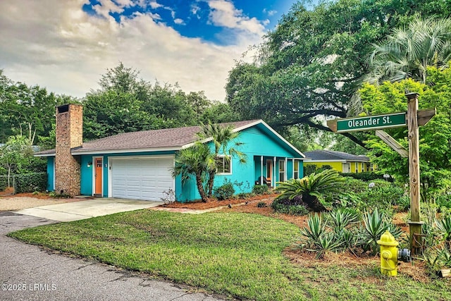 view of front of home with a garage, a front yard, concrete driveway, and a chimney