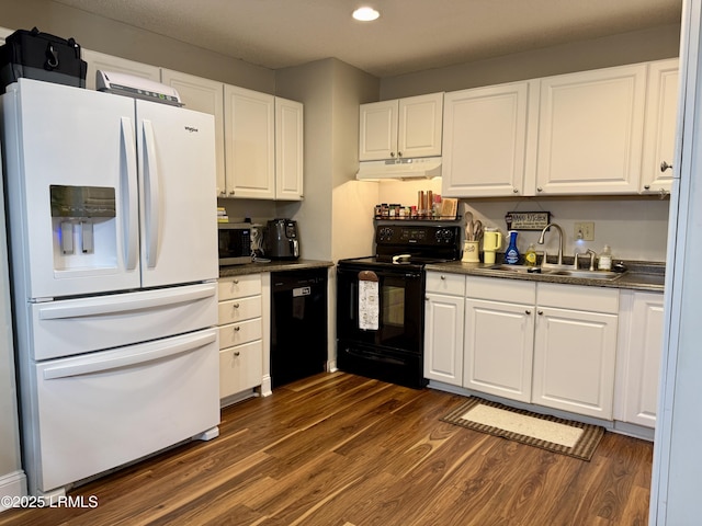 26 Mallard St, Ridgeland, SC 29936 - kitchen featuring black appliances, under cabinet range hood, dark countertops, dark wood finished floors, and white cabinetry
