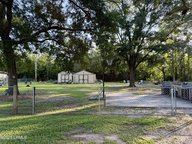 26 Mallard St, Ridgeland, SC 29936 - view of yard with a storage shed and view of wooded area