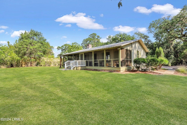 back of house with a yard and a sunroom