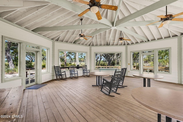 unfurnished sunroom featuring a healthy amount of sunlight and lofted ceiling with beams