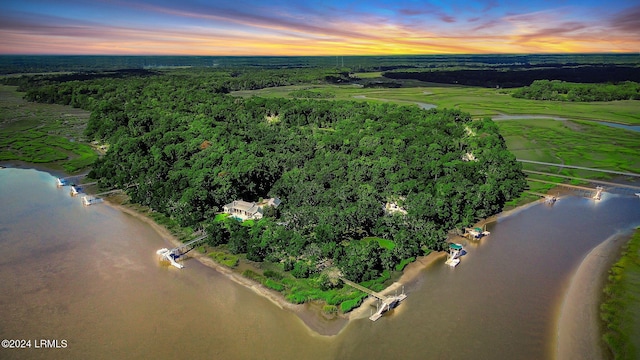 aerial view at dusk featuring a water view