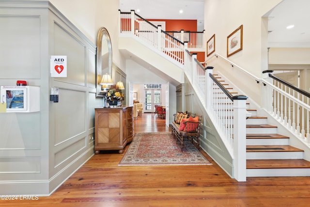 foyer entrance featuring hardwood / wood-style flooring and a towering ceiling