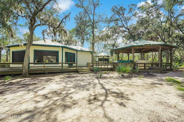 exterior space featuring a gazebo, a deck, and a jacuzzi