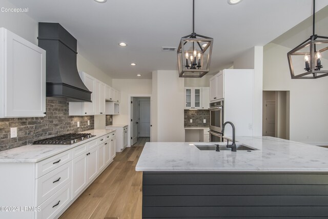 kitchen with an inviting chandelier, hanging light fixtures, stainless steel appliances, and white cabinets