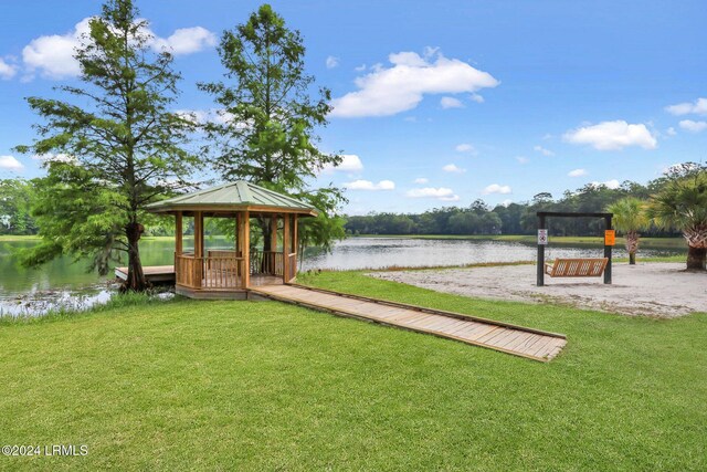 dock area featuring a gazebo, a water view, and a yard