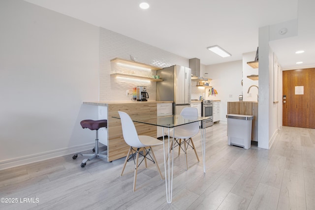 dining room with sink and light hardwood / wood-style floors