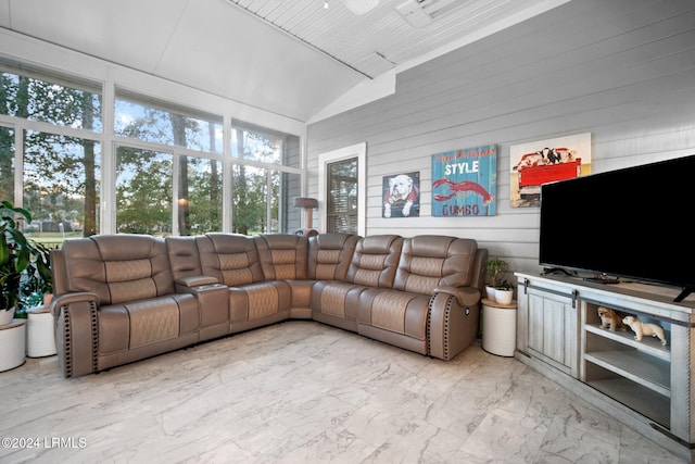 living room featuring lofted ceiling and wood walls