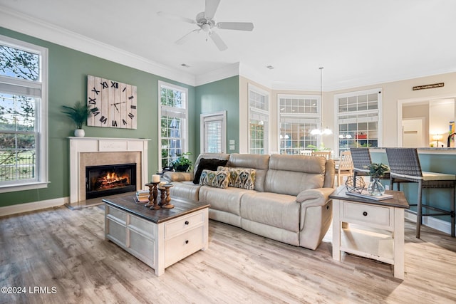 living room with crown molding, light hardwood / wood-style flooring, and a wealth of natural light