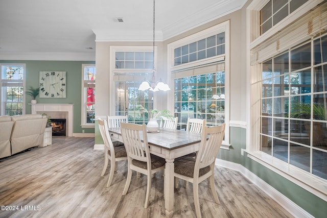 dining area featuring hardwood / wood-style flooring, ornamental molding, and an inviting chandelier