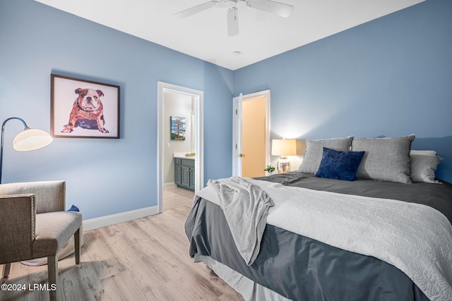 bedroom featuring ceiling fan, ensuite bath, and light wood-type flooring