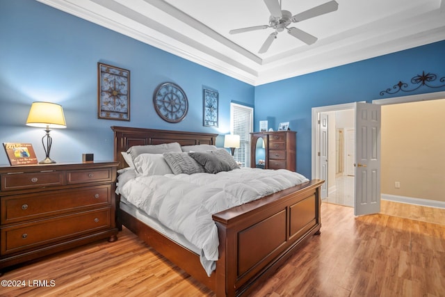 bedroom featuring ornamental molding, light wood-type flooring, and ceiling fan