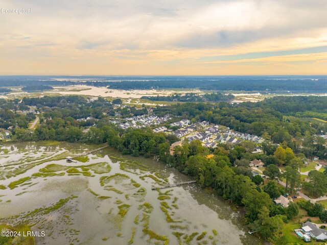 aerial view at dusk featuring a water view