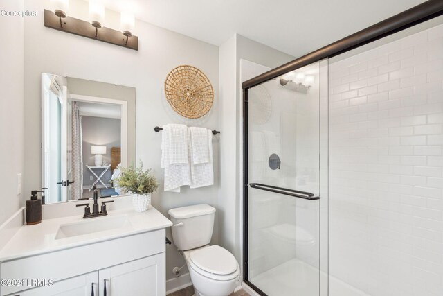 bathroom featuring vanity, toilet, and a shower with shower door