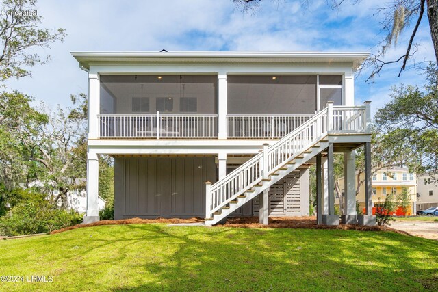 back of property featuring a sunroom and a yard