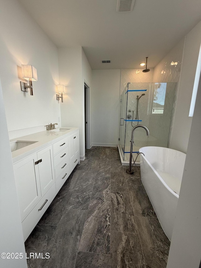 bathroom with double vanity, visible vents, a shower stall, and a freestanding tub